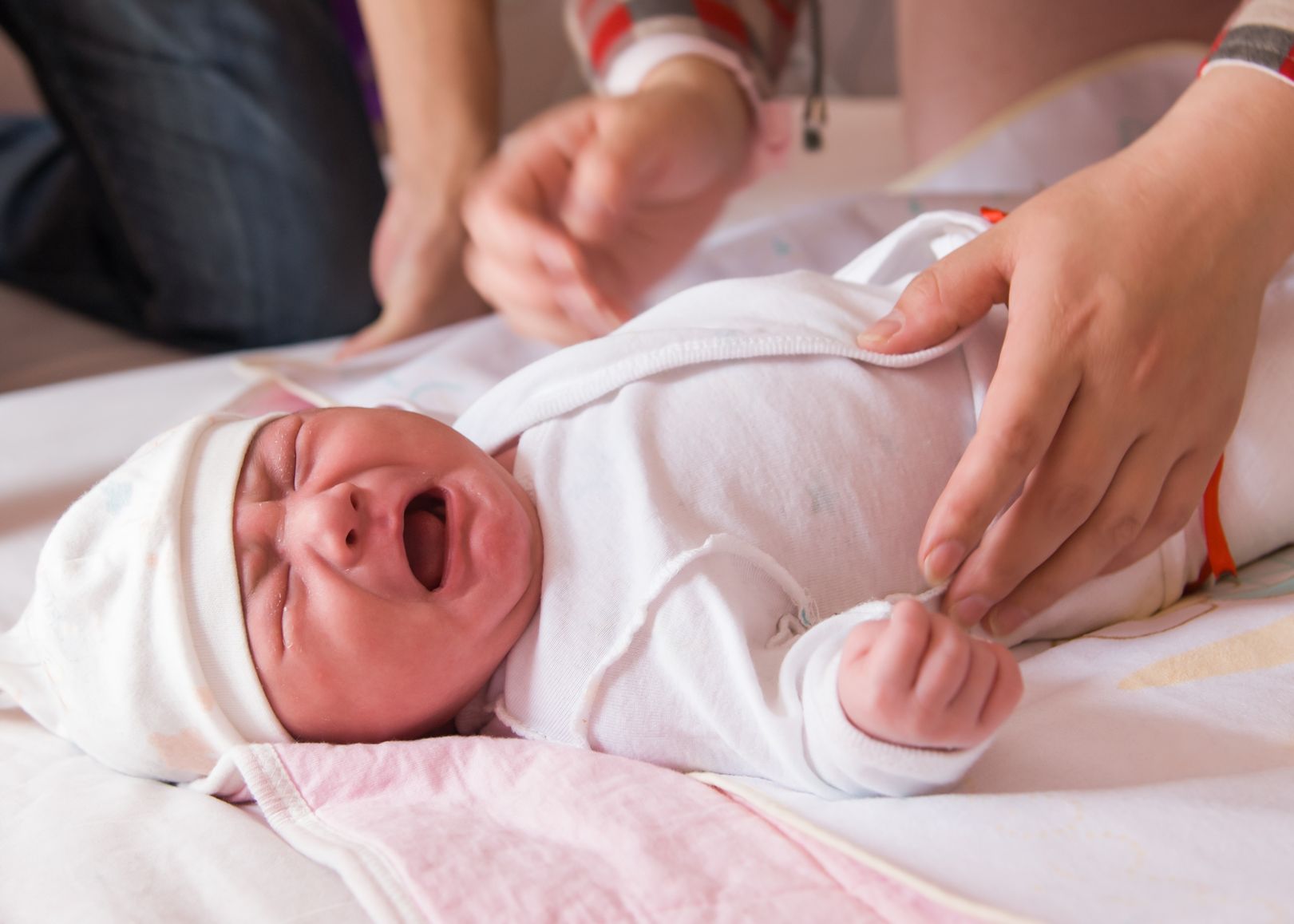 newborn baby crying on the bed, colic